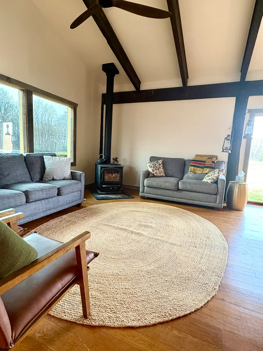 The barn's common room with a wood stove and soft seating